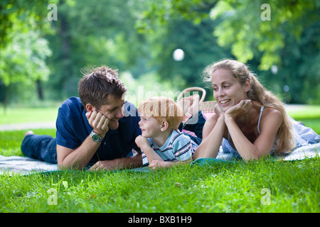 Les parents avec fils couché dans park et à l'écart Banque D'Images