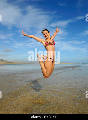 Saut dans l'air, jeune femme de la mer, image symbolique de la vitalité, la soif de vivre, la plage de Sotavento de Jandia beach Banque D'Images