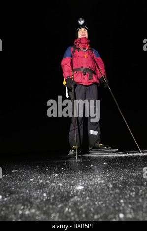 Homme portant un patin à glace et de la tête jusqu'à la torche dans la nuit Banque D'Images