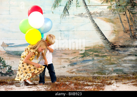 Jeune garçon et fille avec des ballons à la masse au Banque D'Images