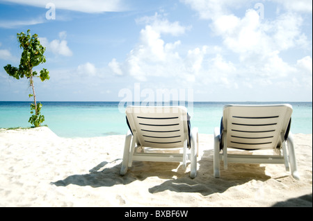 Chaises longues sur la plage aux Maldives Banque D'Images