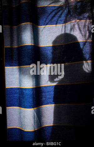 Une femme derrière un rideau Banque D'Images