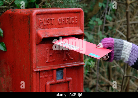 L'affichage des cartes de vœux de Noël femme dans une boîte aux lettres Courrier Royal Banque D'Images