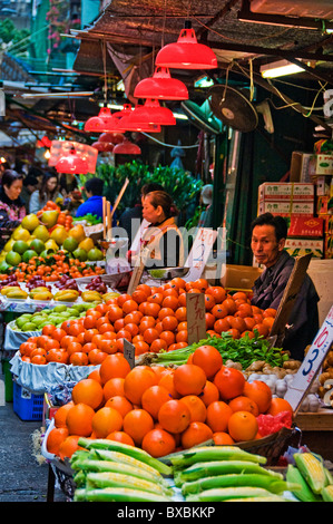 L'homme et de la femme asiatique en plein air qui fréquentent les fruits et légumes du marché à Hong Kong, Chine Banque D'Images