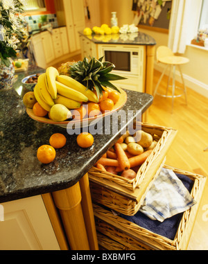 Close-up du plateau de fruits sur le plan de cuisine avec des légumes dans les paniers de stockage Banque D'Images