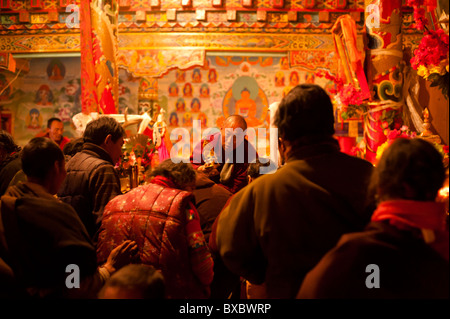 Un moine tibétain lamaïste bénit adhérents lors d'une cérémonie au temple de Tagong, province du Sichuan, Chine. Banque D'Images