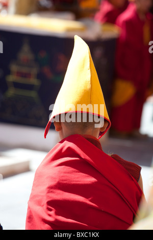 Photo d'un seul moine jaune en robes rouges portant un chapeau jaune Banque D'Images