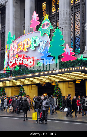 Shoppers & Joyeux Noël signe au-dessus de grand magasin Selfridges entrée principale dans Oxford Street West End de Londres Angleterre Royaume-uni Banque D'Images