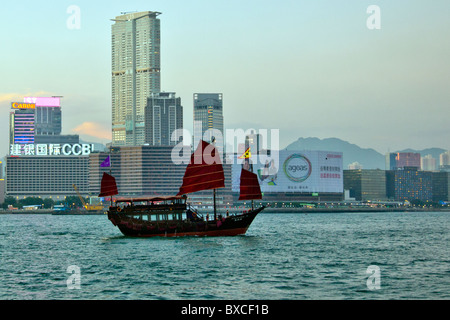 Hong Kong Voyages indésirable sur Victoria Harbour, Port, avec en arrière-plan de Kowloon à extensions rouge vue emblématique voiles Banque D'Images