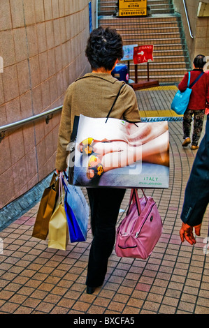 Femme orientale marche sur la rue de la ville avec plusieurs sacs de magasinage Banque D'Images