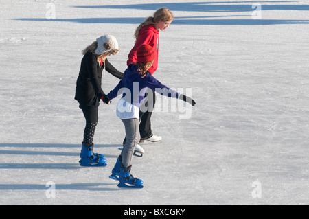 Les enfants profiter de la patinoire de plein air Noël temporaire mis en place de l'extérieur de la Tour de Londres, Londres UK Banque D'Images