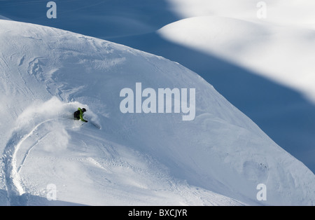 D'un virage, skieur de télémark en poudreuse sur terrain accidenté à Andermatt, Suisse. Banque D'Images