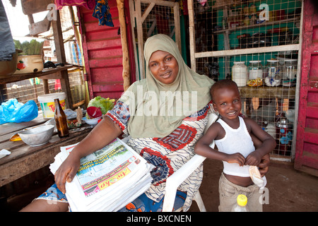 Mme Bella Bah, illustré avec son fils vu Taiub, vend des journaux dans le quartier Funkia, Freetown, Sierra Leone, Afrique de l'Ouest. Banque D'Images