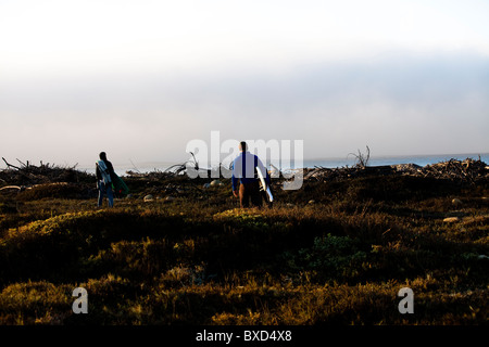 Deux jeunes surfeurs mâles randonnée pédestre le long d'un sentier. Banque D'Images