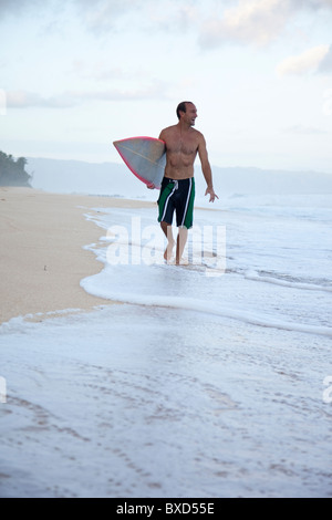 Un surfeur à pipeline, sur la côte nord d'Oahu, Hawaii. Banque D'Images