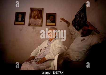 Un Maître Reiki guérison reconnective donne à un patient âgé dans une vieille maison pour les femmes à Mexico Banque D'Images