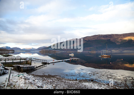 Bateaux sur le Loch Lomond Ecosse neige au sol, des reflets dans l'eau calme Banque D'Images