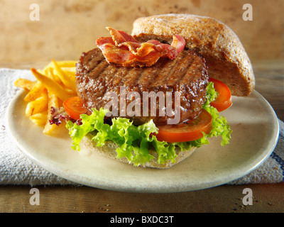 Burger de boeuf au bacon dans une farine pain avec salade et frites Banque D'Images