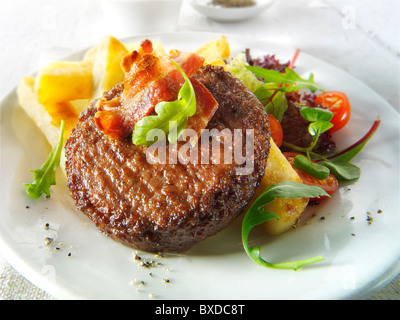 Burger de boeuf grillé et du bacon avec des frites et de la salade chunky Banque D'Images