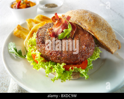 Burger de boeuf au bacon dans une farine pain avec salade et frites Banque D'Images