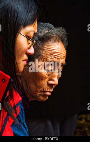 Portrait portraits de jeunes et vieux femmes asiatiques faire offre dans un temple bouddhiste Banque D'Images