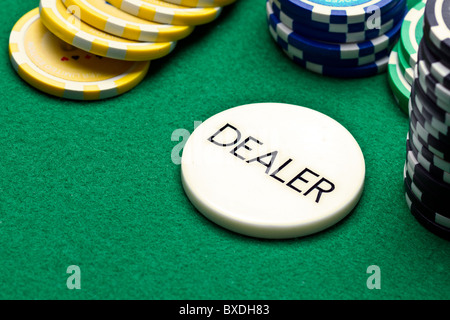 Bouton dealer de poker et jetons sur feutre vert Banque D'Images