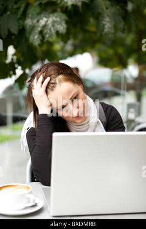 Souligné jeune femme avec un ordinateur portable outdoor Banque D'Images