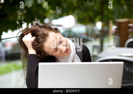 Souligné jeune femme avec un ordinateur portable outdoor Banque D'Images