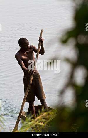 Le pêcheur local polonais sa pirogue le long de la rive de la rivière Zambèze à Livingstone (Zambie). Banque D'Images