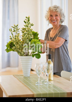 Woman arranging flowers in vase Banque D'Images