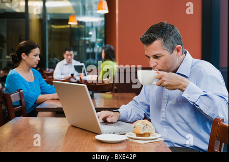 Man working on laptop in restaurant Banque D'Images