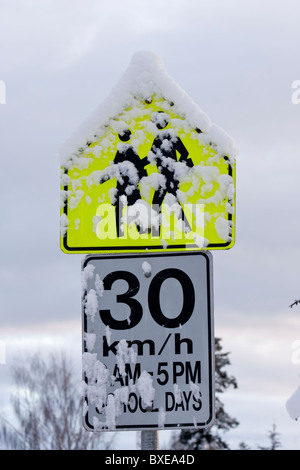 Zone scolaire couvert de neige en hiver, signe de la limite de vitesse-Victoria, Colombie-Britannique, Canada. Banque D'Images