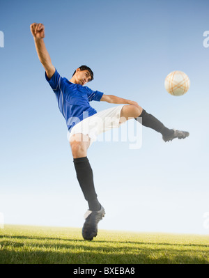 Soccer player kicking ball Banque D'Images