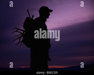 Hunter avec le bois dans son sac à dos Banque D'Images