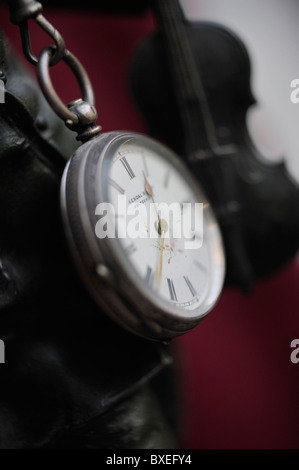 Close-up d'argenterie ancienne montre de poche avec de-violon porté en arrière-plan Banque D'Images