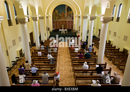 Prêtre donne des bénédictions pendant la messe quotidienne à l'église catholique Saint-laurent de Feltham, Londres. Banque D'Images