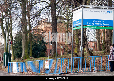 Une femme se tient en dehors de Nottingham City Hospital fumer une cigarette Banque D'Images