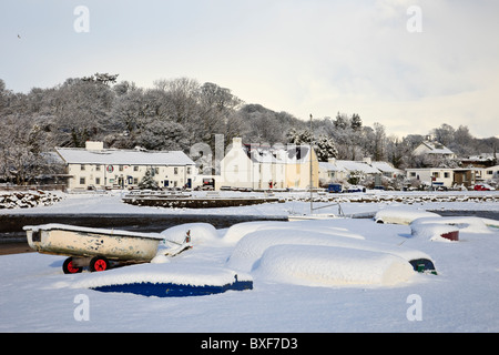 Quai rouge Bay (Traeth Coch), l'île d'Anglesey, dans le Nord du Pays de Galles, Royaume-Uni, Europe. Scène de neige avec le bateaux sur la côte en hiver Banque D'Images