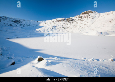 Easedale Tarn au-dessus de Grasmere dans le Lake District, UK, gelé par une vague de froid en décembre 2010. Banque D'Images