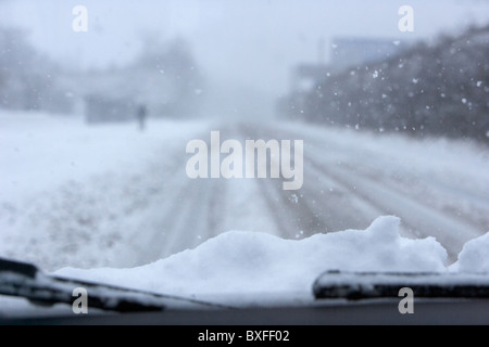 Voiture avec de la neige sur le capot en voiture sur une route gelée froide par une froide journée d'hiver froid des hivers enneigés neige météo Irlande du Nord Belfast routes Banque D'Images