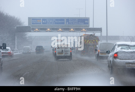 Le sablage des chasse-neige camion descendant d'autoroute sur un jour froid des hivers enneigés de l'Irlande du Nord Belfast Banque D'Images