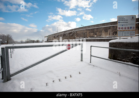 Le marché des bovins en parc de voiture Launceston UK couvertes de neige, pas d'entrée fermé avec un signe sur la barrière d'accès Banque D'Images