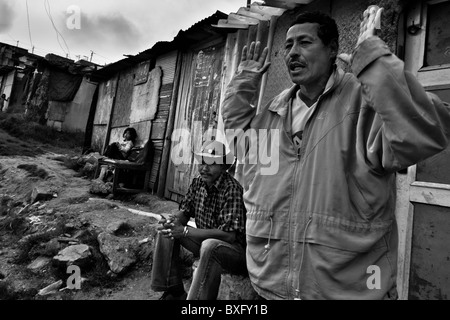 Un homme de déplacées département de Caquetá parle en face de sa maison, dans le bidonville de Ciudad Bolívar, Bogota, Colombie. Banque D'Images