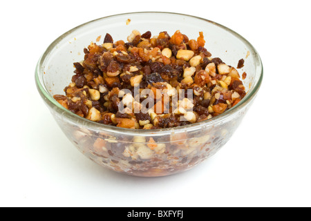 Bol en verre pour gâteau de Noël de noix et fruits à profiter ajouté le rhum, le cognac et le sherry. Banque D'Images