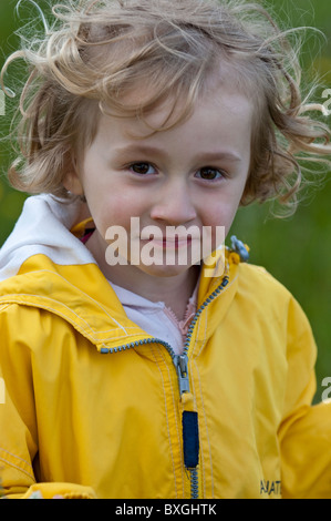 Petite fille portant un imperméable jaune, Provence, France. Banque D'Images