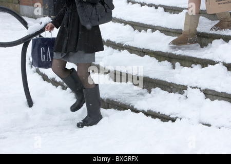 Deux femmes walking down steps sur un jour froid des hivers enneigés de l'Irlande du Nord Belfast Banque D'Images