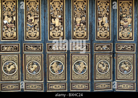 La Chine, le Yunnan, Jianshui. Reliefs sculptés d'or couvrir porte pliante panneaux ; jardin de la famille Zhu. Banque D'Images