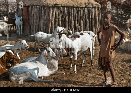 Garçon à la recherche après l'Himba chèvres dans un village près d'Epupa Falls, Kunene, Namibie, Afrique. Banque D'Images