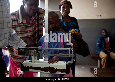 Un enfant meurt du SIDA est pesé comme elle est vérifiée dans un centre d'alimentation spéciaux à Kampala, Ouganda, Afrique de l'Est. Banque D'Images