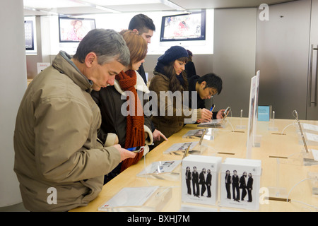 Les clients d'essayer les iphone à l'Apple Store, Carrousel du Louvre, Paris, France Banque D'Images